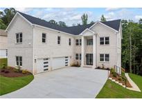 Stunning two-story home with a white brick facade, large windows, and a spacious three-car garage at 4267 Matisse Ln, Fairburn, GA 30213