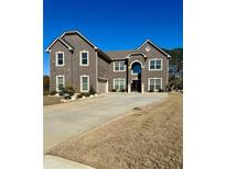 Two story home with gray brick exterior and a three car garage at 184 Camdale Ct, Mcdonough, GA 30252