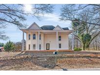 Two story home featuring a wrap around porch and unique architectural details at 119 E Johnson E St, Temple, GA 30179