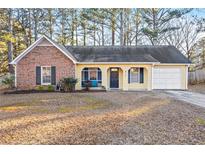 Brick and yellow sided ranch home with attached garage and screened porch at 812 Bartow Ct, Riverdale, GA 30274