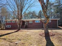 Brick ranch house with mature trees and a landscaped yard at 6242 Prestley Mill Rd, Douglasville, GA 30134