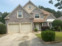 Charming two-story home with a brick facade, a two-car garage, and well-maintained landscaping at 7981 Gossamer Dr, Fairburn, GA 30213