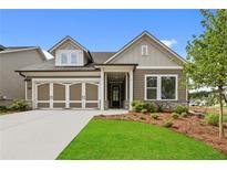 Charming single-Gathering home with a two-car garage, stone accents, manicured lawn and inviting covered entry at 2012 Ripple Park Bnd, Canton, GA 30114