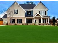 Charming two-story home showcasing a well-manicured lawn and a welcoming facade with stone and siding accents at 1421 Stephens View Dr, Loganville, GA 30052