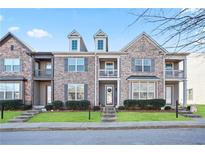 Brick front three-story townhome with landscaping and steps at 7711 Cabrini Pl, Fairburn, GA 30213