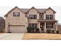 Two-story brick home with a two-car garage and landscaped yard at 1690 Geranium Ln, Cumming, GA 30040