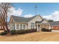 Tan house with gray roof, stone accents, and landscaping at 1003 Somerton Pl, Cumming, GA 30040