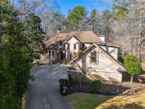 Elegant two-story house with a large driveway and mature trees surrounding at 5041 Towne Lake N Hls, Woodstock, GA 30189