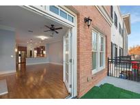 Spacious living room featuring hardwood floors, ceiling fan, and an open layout into kitchen area at 340 Town Center Ave # 215, Suwanee, GA 30024