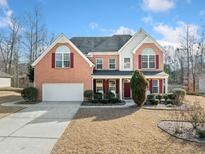 Brick two-story house with a large front yard and a two-car garage at 1158 Mitford Ln, Dacula, GA 30019