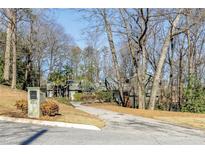 Attractive home exterior with long driveway, nestled among mature trees at 285 Glen Lake Dr, Sandy Springs, GA 30327