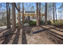 Charming home with a front porch surrounded by trees creating a tranquil, natural setting at 380 Oak Landing Cir, Douglasville, GA 30134