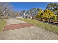 Spacious front yard with long driveway, lush landscaping, and mature trees at 4320 Chapel Hill Farms Dr, Douglasville, GA 30135