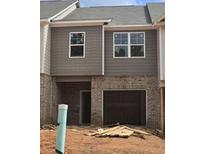 Exterior view of home with gray siding and brick, and attached garage awaiting completion at 2812 Lillian Ln, Douglasville, GA 30135
