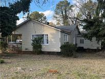 Tan vinyl-sided house with front porch and yard at 4402 Highland Rd, Decatur, GA 30035
