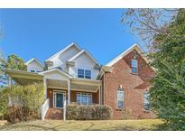 Brick two-story house with a front porch and landscaped yard at 3580 Bulloch Lake Rd, Loganville, GA 30052