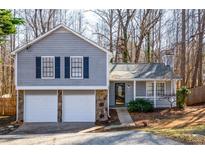 Gray house with white two-car garage and landscaped yard at 3276 Rollingbrook Way, Duluth, GA 30096