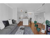 Bright living room with a gray sofa, marble coffee table, and view to the kitchen at 2700 Pine Tree Ne Rd # 2306, Atlanta, GA 30324