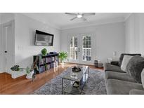Bright living room with hardwood floors, ceiling fan, and doors leading to a balcony or patio at 2700 Pine Tree Ne Rd # 2306, Atlanta, GA 30324