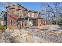 Brick home with stone patio and driveway, nestled in a wooded setting at 1422 Hillside Dr, Grayson, GA 30017