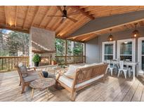 Relaxing covered back porch with fireplace and seating area at 2085 Melrose Trce, Cumming, GA 30041