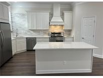 Bright kitchen with an island, stainless steel appliances and white cabinetry and backsplash at 3215 Concord Cir, Smyrna, GA 30080