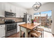 Bright kitchen with white cabinets, stainless appliances, and breakfast table with easy access to balcony at 100 Brickworks Cir # 102, Atlanta, GA 30307