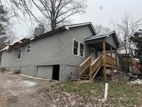 Gray house with wooden stairs and damaged roof awaiting repairs at 277 Barfield Sw Ave, Atlanta, GA 30310