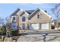 Two-story house with tan exterior, two-car garage, and landscaping at 4201 N Mountain Ne Rd, Marietta, GA 30066