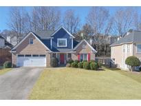 Two-story house with blue and beige accents, two-car garage, and manicured lawn at 690 Winding River Dr, Lawrenceville, GA 30046