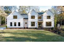 Two-story house with white siding, black windows, and a grassy lawn at 1731 N Springs Dr, Dunwoody, GA 30338