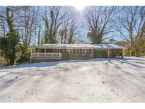 Brick ranch house with covered porch, carport, and snow-covered yard at 190 Highland Blvd, Stockbridge, GA 30281