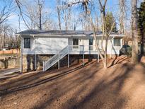 White ranch house with stone accents and a deck at 3920 Stone Creek Cir, Cumming, GA 30041