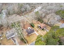 Aerial view of house and property, showing surrounding trees and river at 900 Sage Nw Ln, Conyers, GA 30012