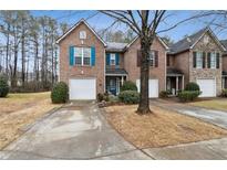 Brick townhome featuring colorful shutters and a well-maintained front yard at 245 Fern Crest Dr, Lawrenceville, GA 30046