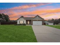 Ranch style home with stone accents, two-car garage, and landscaped yard at 7 Little Creek Manor Dr, Dallas, GA 30157