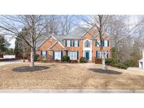 Charming brick home with blue shutters and a well-manicured front yard at 305 Corrigan Trce, Peachtree City, GA 30269