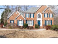 Two-story brick home with blue shutters and well-manicured landscaping at 305 Corrigan Trce, Peachtree City, GA 30269