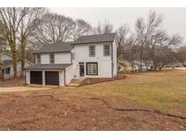 Two-story house with white siding, black trim, and a two-car garage at 684 Tarkington Rd, Stone Mountain, GA 30088