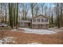 Two-story house with brick and siding exterior, nestled among trees at 2026 Morris Dr, Riverdale, GA 30296