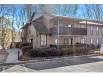 Exterior view of condo building with parking and landscaping at 1301 Cumberland Se Ct, Smyrna, GA 30080