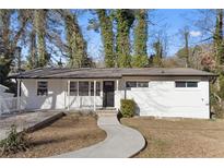 Newly renovated ranch home with a white brick exterior, landscaped lawn, and walkway at 2529 Dale Creek Nw Dr, Atlanta, GA 30318