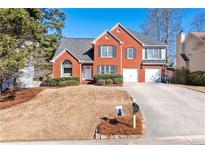Brick house with two-car garage and landscaped yard at 1111 Lauren Nw Way, Acworth, GA 30101