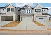 New townhomes featuring brick and siding exteriors with attached garages and concrete driveways at 4178 Waratah Way, Mableton, GA 30126