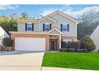 Two-story house with brick and siding, a large yard, and a two-car garage at 6397 Barker Station Walk, Sugar Hill, GA 30518