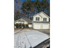 Two-story house with a two-car garage and snow-covered yard at 3575 Oakvale Falls Ct, Decatur, GA 30034