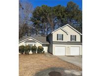 Tan two-story house with a two-car garage and manicured lawn at 3575 Oakvale Falls Ct, Decatur, GA 30034