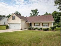 Ranch style home with attached garage, manicured lawn and landscaping at 775 Freeman Dr, Covington, GA 30016