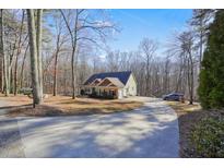 Ranch style home with large covered porch and attached garage, situated on a wooded lot at 159 Geneva Rd, Canton, GA 30114