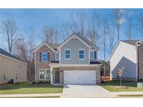 Two-story brick home with gray siding, white garage door, and landscaping at 277 Tulip Dr, Covington, GA 30016